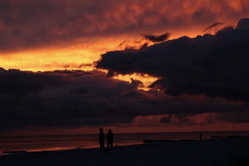 People walk the beach in Treasure Island