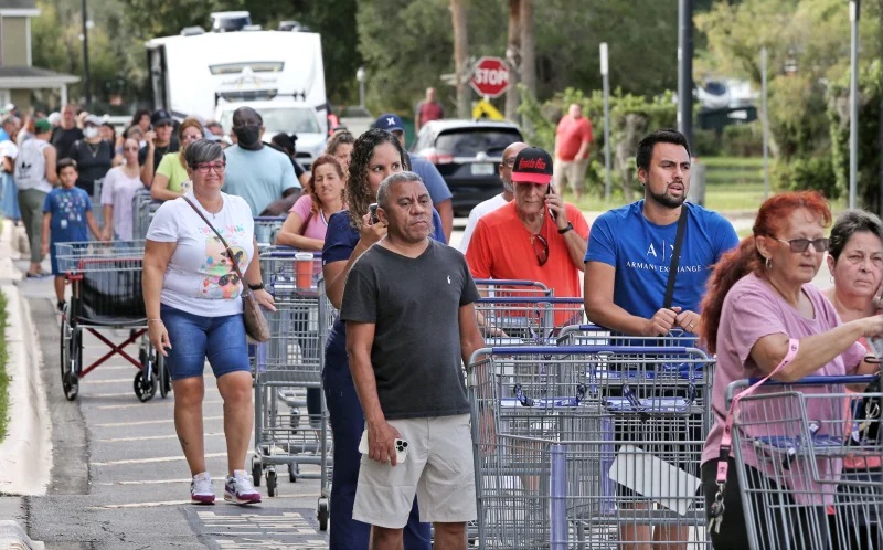 Shoppers wait in line outside a retail warehouse